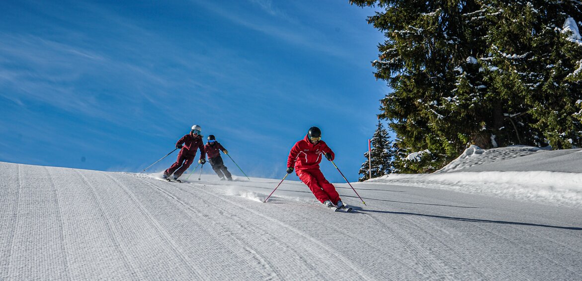 Ein Skilehrer fährt mit zwei Personen beim Privatkurs die Piste hinunter. | © Silvretta Montafon - Vanessa Strauch