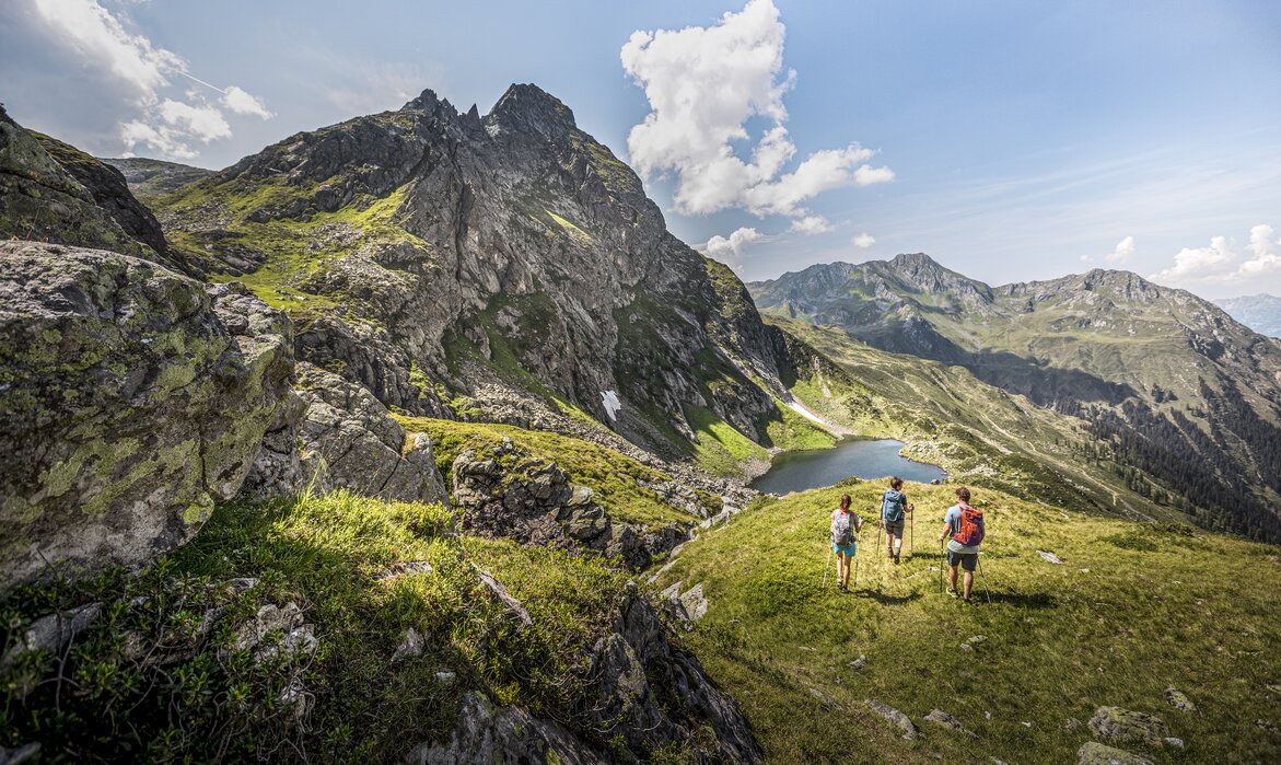 Drei Personen wandern Richtign Herzsee im Sommer am Hochjoch in der Silvretta Montafon. | © Silvretta Montafon - Stefan Kothner