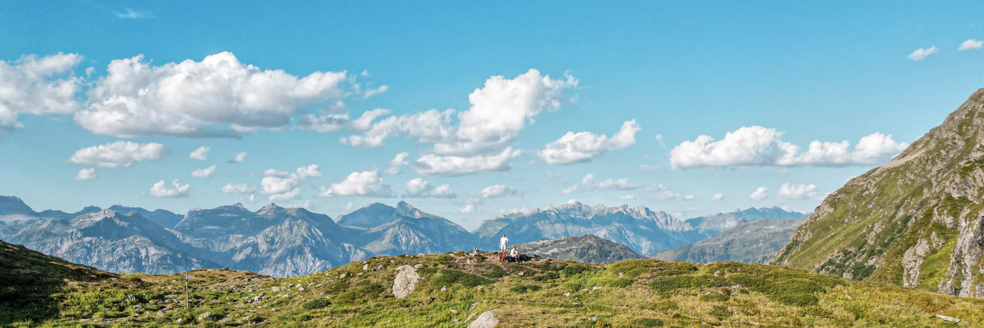 Ein Bergsee im Sommer mit zwei Personen in Hintergrund. | © Silvretta Montafon - Vanessa Strauch