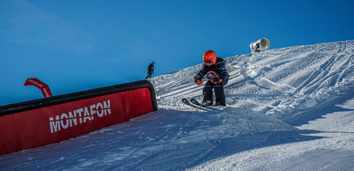 Ein Kind fährt auf einen Kicker im Snowpark während des Skikurses in der Silvretta Montafon. | © Silvretta Montafon - Vanessa Strauch