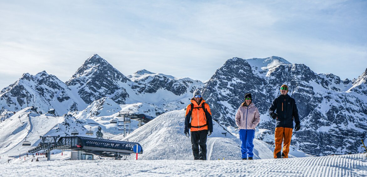 Drei Winterwanderer laufen an der Bergstation auf dem Wanderweg bei schönsten Winterwetter. | © Silvretta Montafon - Vanessa Strauch
