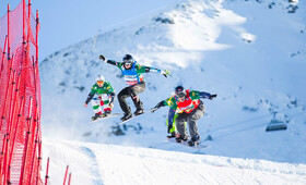 Vier Sportler sausen um die Wette Richtung Ziel beim Snowboardcross Rennen beim Weltcup 15/16 in der Silvretta Montafon