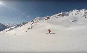 Eine Skifahrerin saust die frische Piste im Sonnenschein in der Silvretta Montafon hinunter