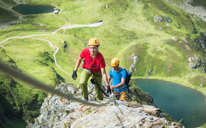 Zwei Personen in Kletterausrüstung besteigen das letzte Stück des Klettersteigs im Seetal