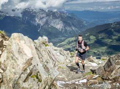 Ein Teilnehmer rennt den Berg auf der Strecke hinauf zwischen Steinen