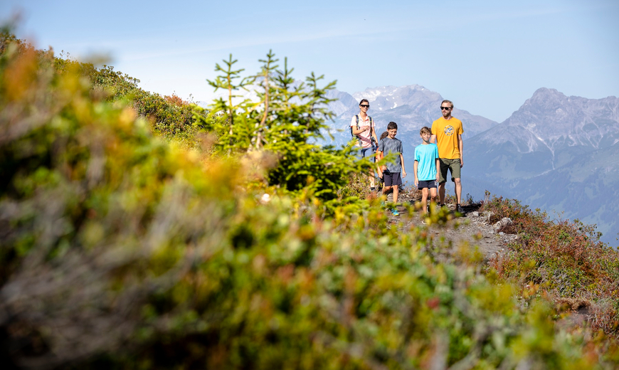 Eine Familie wandert dem Wanderweg am Abenteuerberg Hochjoch entlang