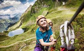 Zwei Kinder klettern den Klettersteig im Seetal hinauf im Montafon