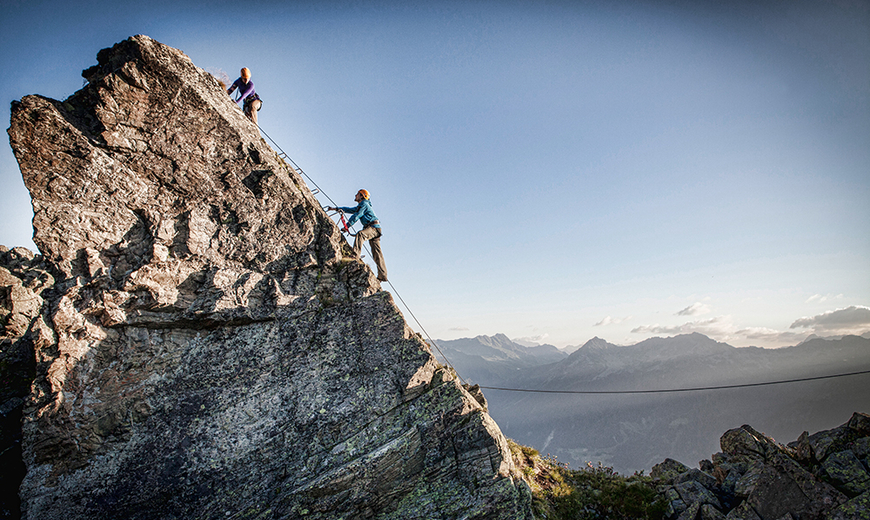 Zwei Personen klettern die Bergspitze des Klettersteig Burg im Montafon entlang