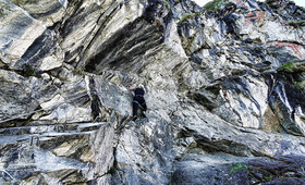 Eine Person klettert den Felsen beim Klettersteig Hochjoch entlang