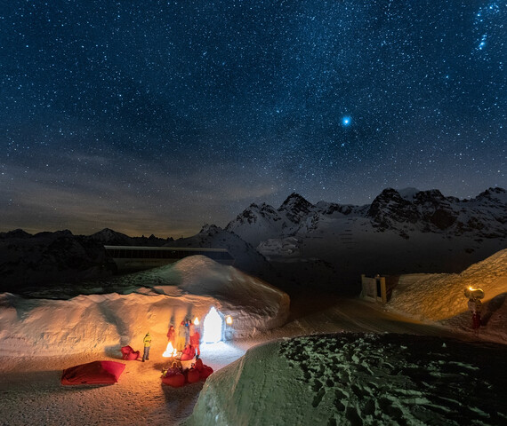 Igludorf von einem Hügel fotografiert mit Sternenhimmel im Hintergrund in der Silvretta Montafon