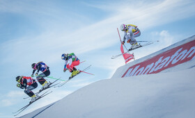 Die vier Ski Cross Wettbewerber springen über die Schanze auf der Wettstrecke