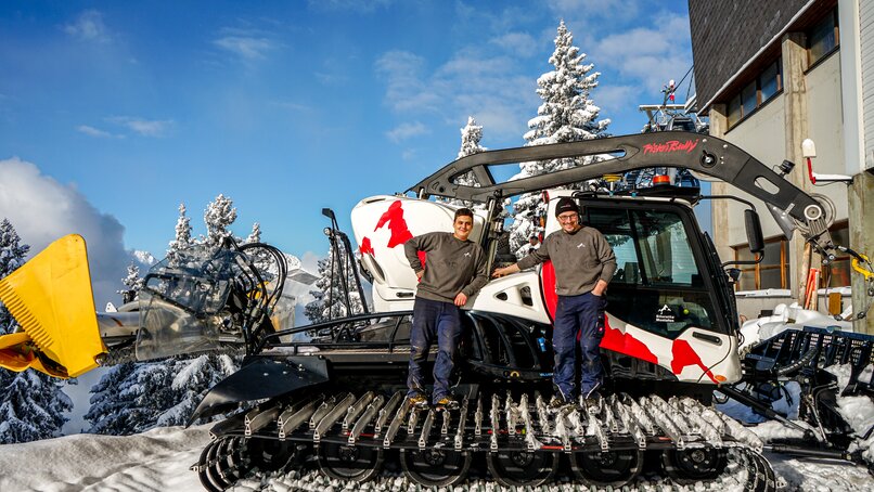 Zwei Personen Auf dem Pistenbully in der Werkstatt der Silvretta Montafon  | © Vanessa Strauch - Silvretta Montafon 