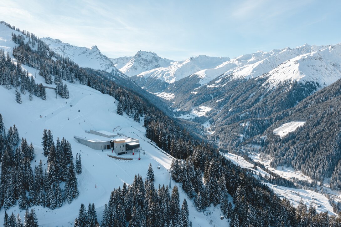 Die Valisera Bahn Mittelstation der Silvretta Montafon im Winter mit verschneiten Bergen und der Piste | © Silvretta Montafon - Mathäus Gartner