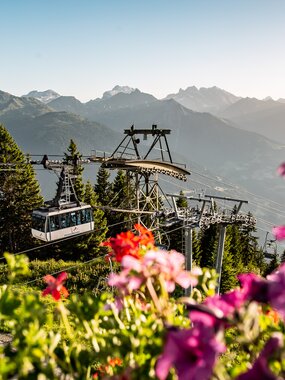 Hochjoch Bahn - Silvretta Montafon | © Silvretta Montafon - Friederike Weber Die Hochjoch Bahn der Silvretta Montafon schwebt in die Bergstation mit schönen Blumen im Vordergrund | © Silvretta Montafon - Friederike Weber