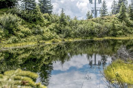 Die Grasjoch Bahn schwebt über einen Teich in den Bergen der Silvretta Montafon | © Silvretta Montafon - Marc Obrist