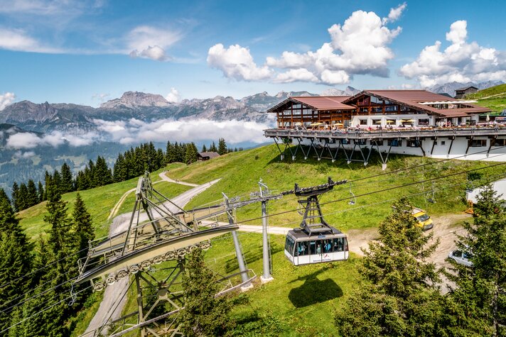 Eine Kabinenbahn fährt im Sommer zur Bergstation, wo sich ein Bergrestaurant mit großer Sonnenterrasse befindet. | © Silvretta Montafon - Stefan Kothner