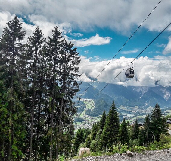 Die Zamang Bahn schwebt über dem Wald mit Wolken im Hintergrund zur Bergstation hoch. | © Silvretta Montafon