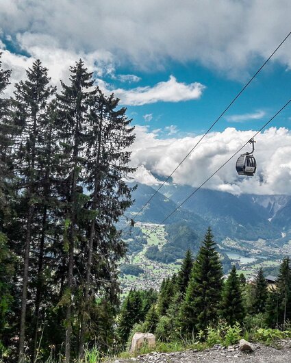Die Zamang Bahn schwebt über dem Wald mit Wolken im Hintergrund zur Bergstation hoch. | © Silvretta Montafon