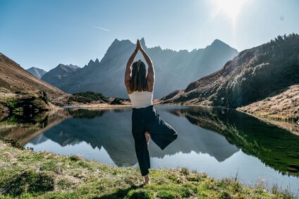 Eine Frau macht Yoga vor einem Bergsee in den Bergen | © Silvretta Montafon - Marie Rudigier