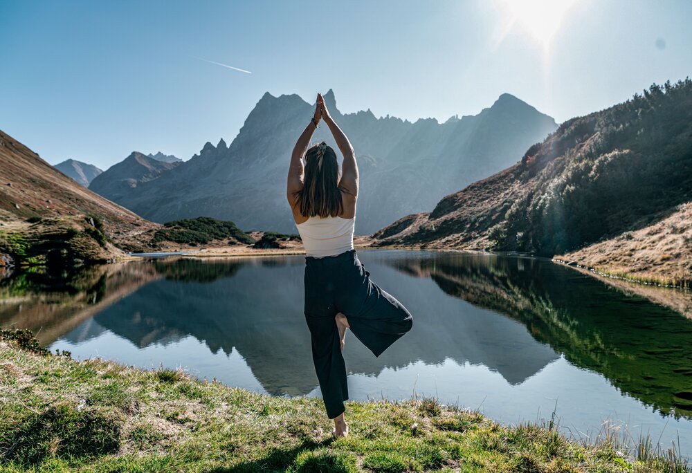 Eine Frau macht Yoga vor einem Bergsee in den Bergen | © Silvretta Montafon - Marie Rudigier