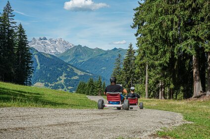 Eine Gruppe fährt mit den Gravity Carts eine Bergstrasse in der Silvretta Montafon hinunter. | © Silvretta Montafon - Vanessa Strauch
