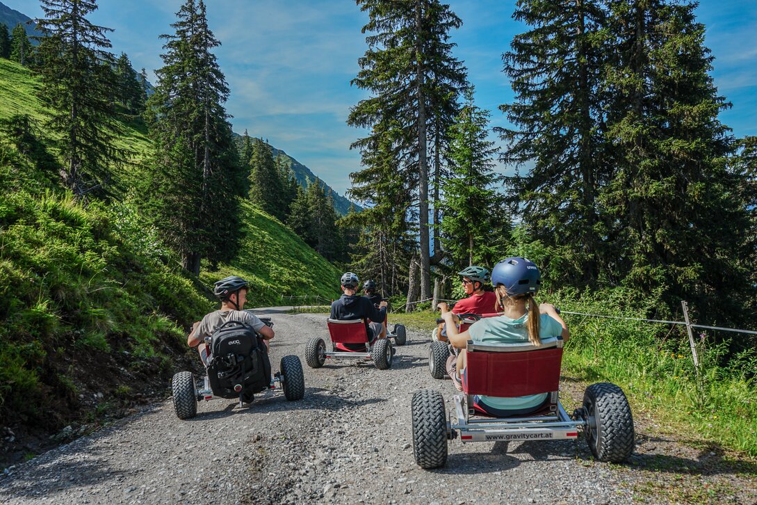 Eine Gruppe steht mit den Gravity Carts auf einer Bergstrasse in der Silvretta Montafon. | © Silvretta Montafon - Vanessa Strauch