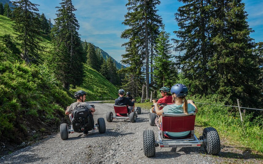 Eine Gruppe steht mit den Gravity Carts auf einer Bergstrasse in der Silvretta Montafon. | © Silvretta Montafon - Vanessa Strauch