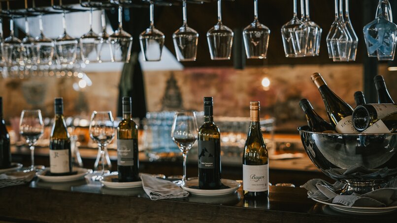 Weingläser und Weinflaschen in einer Weinstube. | © Silvretta Montafon - Vanessa Strauch