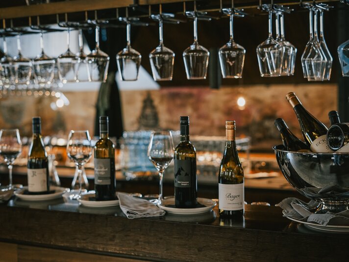 Weingläser und Weinflaschen in einer Weinstube. | © Silvretta Montafon - Vanessa Strauch