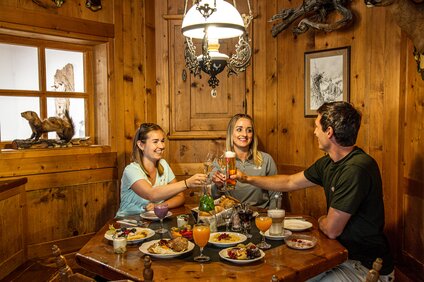 Drei Personen in einer gemütlichen Holzstube beim Bergfrühstück in der Nova Stoba in der Silvretta Montafon. | © Silvretta Montafon - Vanessa Strauch