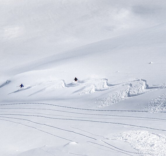 Zwei Freerider ziehen bei der Abfahrt eine kurvige Spur in den Schnee in der Silvretta Montafon. | © Silvretta Montafon - Andreas Vigl