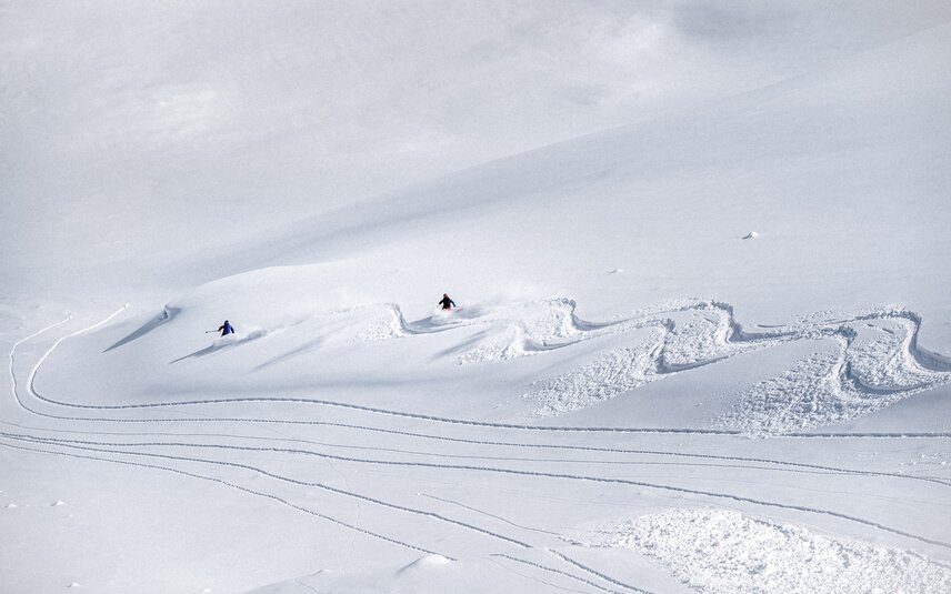 Zwei Freerider ziehen bei der Abfahrt eine kurvige Spur in den Schnee in der Silvretta Montafon. | © Silvretta Montafon - Andreas Vigl