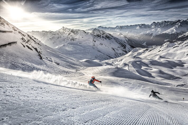 Zwei Skifahrer bei aufgehender Sonne auf der Skipiste in der Silvretta Montafon. | © Silvretta Montafon - Andreas Frank