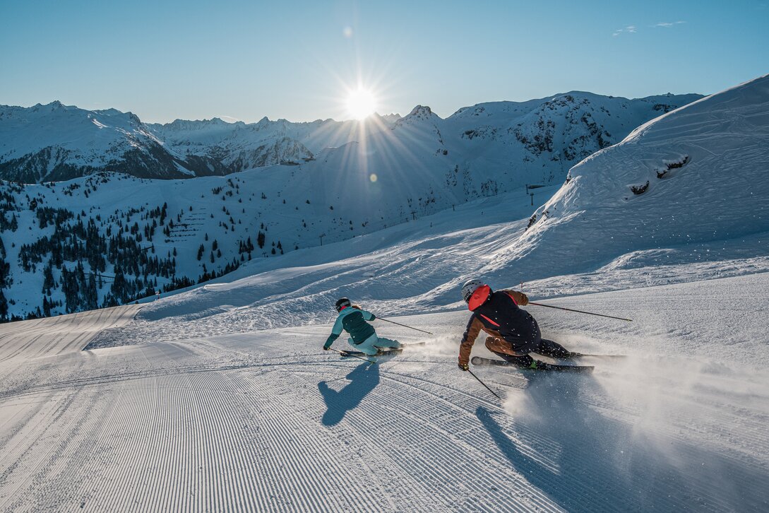 Zwei Skifahrer auf unverspurter Piste im Morgenlicht. | © Daniel Hug - Silvretta Montafon