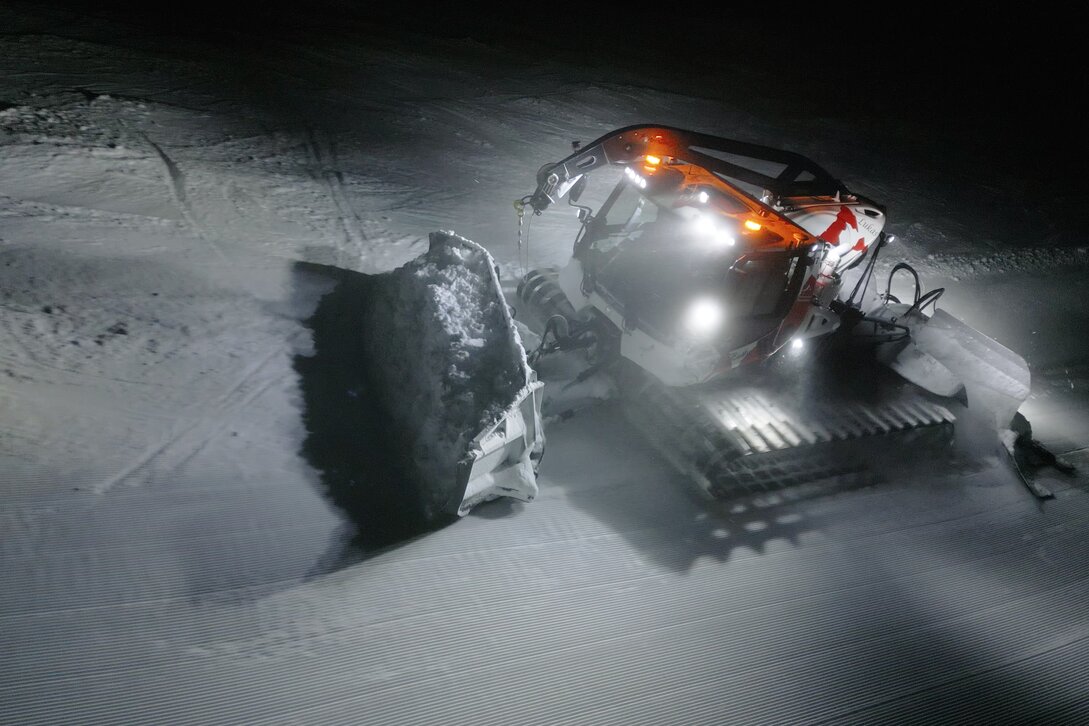 Ein Pistenbully schiebt Schnee in der Nacht auf einer Skipiste. | © Silvretta Montafon