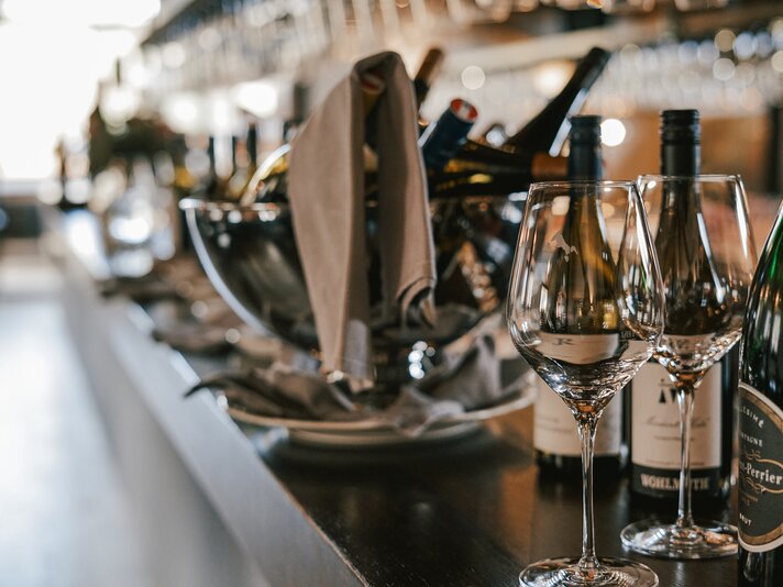 Weingläser und Wein auf einer Theke in einer Weinstube. | © Silvretta Montafon - Vanessa Strauch