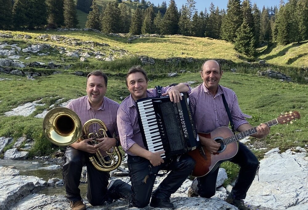 Die Alpenrammler - Silvretta Montafon | © Silvretta Montafon - Werner Konzett Drei Männer in karierten Hemder mit Musikinstrumenten in den Bergen | © Silvretta Montafon - Werner Konzett