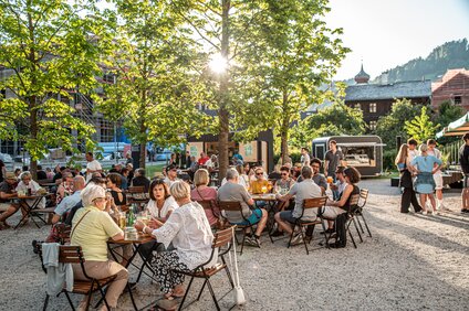 Viele Menschen sitzen auf der Terrasse vom St. Josefsheim und genießen ein Getränk mit Freunden | © Silvretta Montafon - Friederike Weber