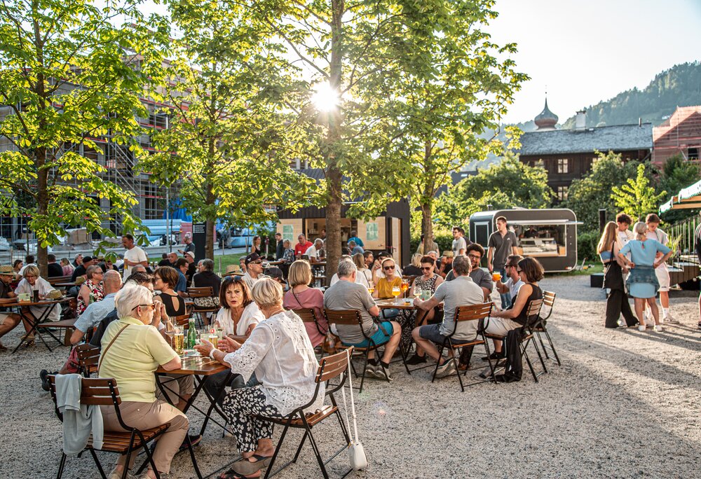 Viele Menschen sitzen auf der Terrasse vom St. Josefsheim und genießen ein Getränk mit Freunden | © Silvretta Montafon - Friederike Weber