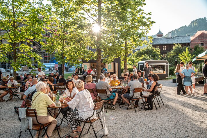 Viele Menschen sitzen auf der Terrasse vom St. Josefsheim und genießen ein Getränk mit Freunden | © Silvretta Montafon - Friederike Weber