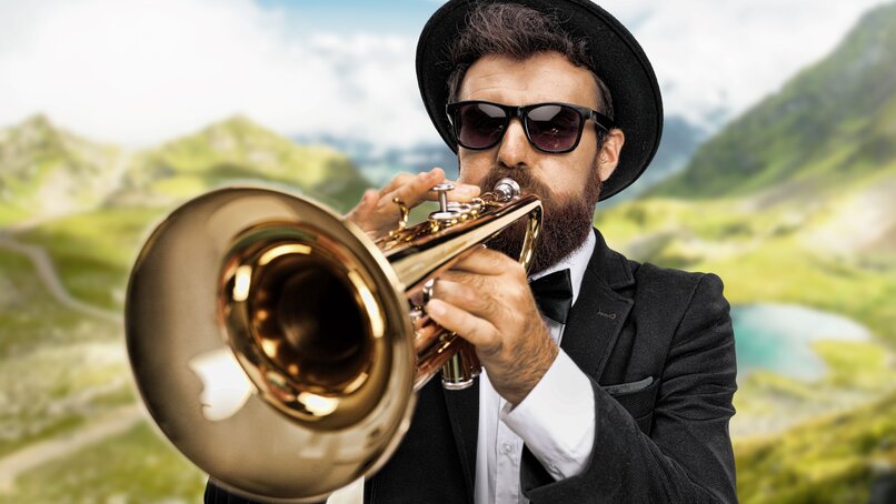 Ein Musiker mit und und Sonnenbrille spielt auf einer Trompete in der Silvretta Montafon.  | © Silvretta Montafon