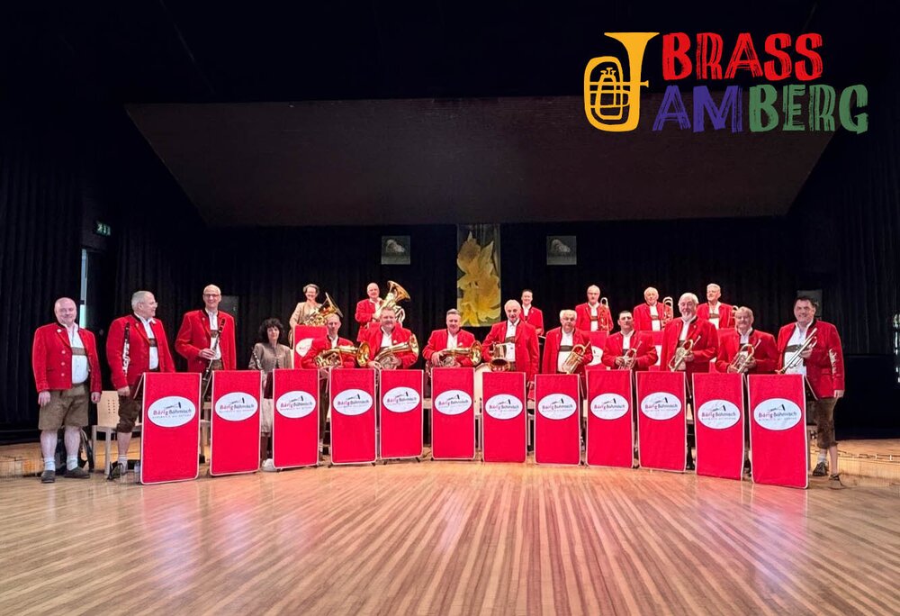 Gruppenbild einer Blaskappelle in roter Tracht auf einer Bühne. | © Silvretta Montafon - Bärig Böhmisch