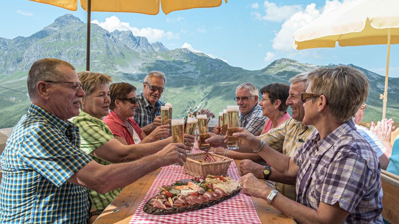 Acht Personen stoßen mit einem Bier an. | © Silvretta Montafon - Jutta Detjen