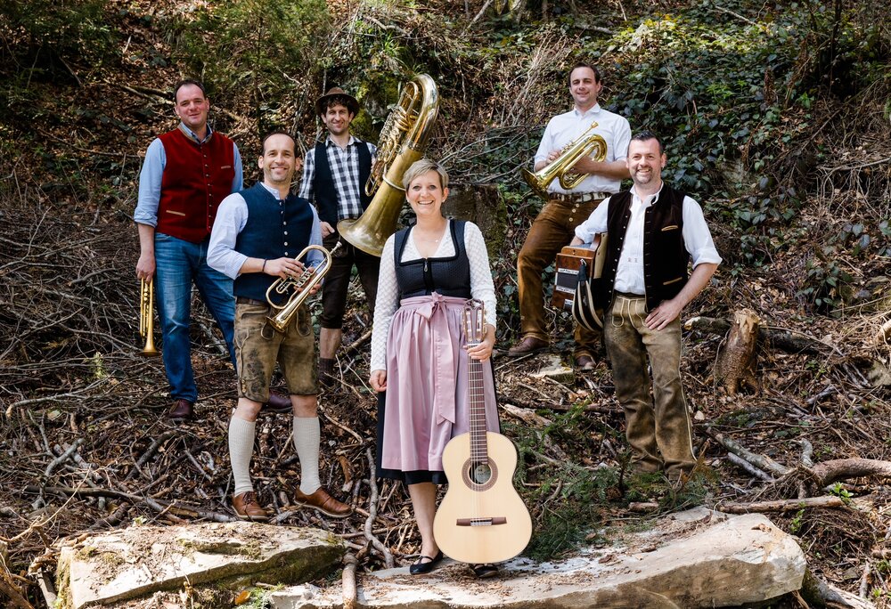Fünf Musikanten in Dirndl und Lederhose mit ihren Instrumenten | © Alpdudler