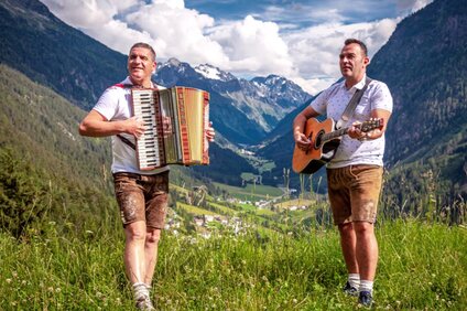 Zwei Musikanten in den Bergen mit Ziehharmonika und Gitarre. | © Die Oberleiner und Freunde