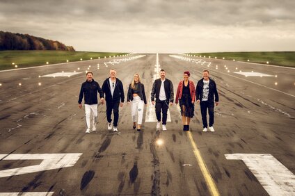 Die Band Changes gehend am Flughafen auf dem Rollfeld. | © Silvretta Montafon - Changes
