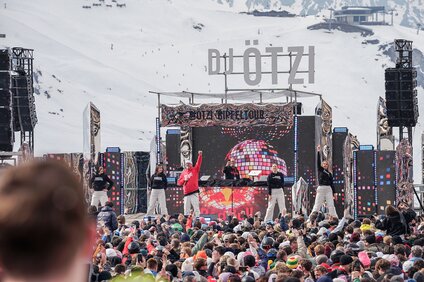 DJ Ötzi und seine Tanzgruppe performen auf einer großen Bühne im Skigebiet Silvretta Montafon. | © Silvretta Montafon - Vanessa Strauch