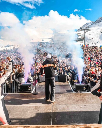 Eine Bühne mit Tämzern und Musikern und die Menschenmenge im Hintergrund Mitten im Skigebiet Silvretta Montafon. | © Silvretta Montafon - Vanray Pictures