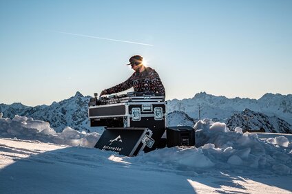 Ein DJ am Pult mitten im Schnee im Skigebiet Silvretta Montafon. | © Silvretta Montafon - Frederike Weber