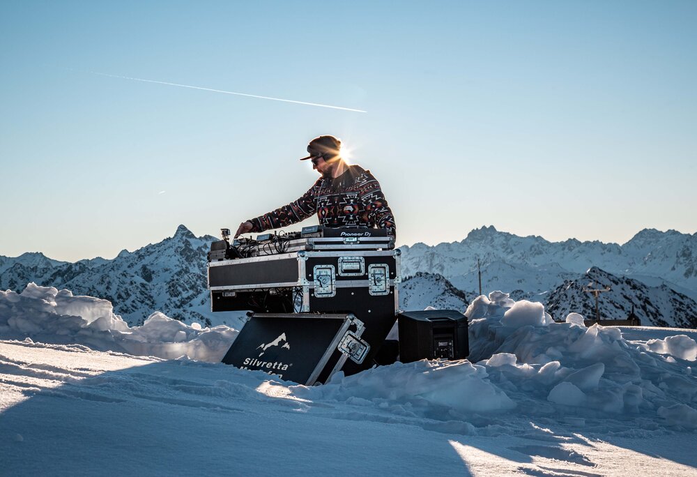 Ein DJ am Pult mitten im Schnee im Skigebiet Silvretta Montafon. | © Silvretta Montafon - Frederike Weber